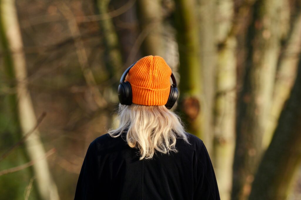 A young blonde woman listening to headphones