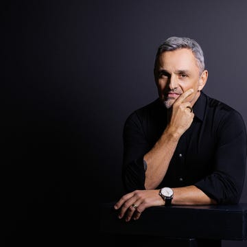 portrait of a man in a black shirt resting his chin on his hand portrait of a man in a black shirt resting his chin on his hand
