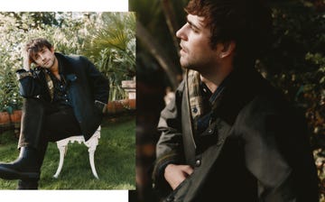 outdoor portrait of a person seated on a white chair dressed in a dark jacket and checkered shirt with a natural background
