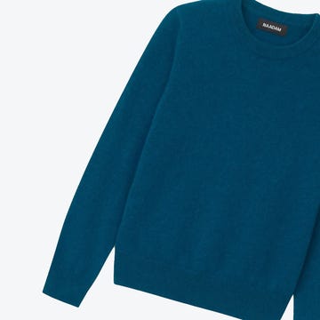 peacock blue naadam cashmere sweater against a white background peacock blue naadam cashmere sweater against a white background