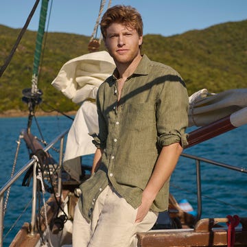 a person on a sailboat against a scenic water and mountainous backdrop a person on a sailboat against a scenic water and mountainous backdrop