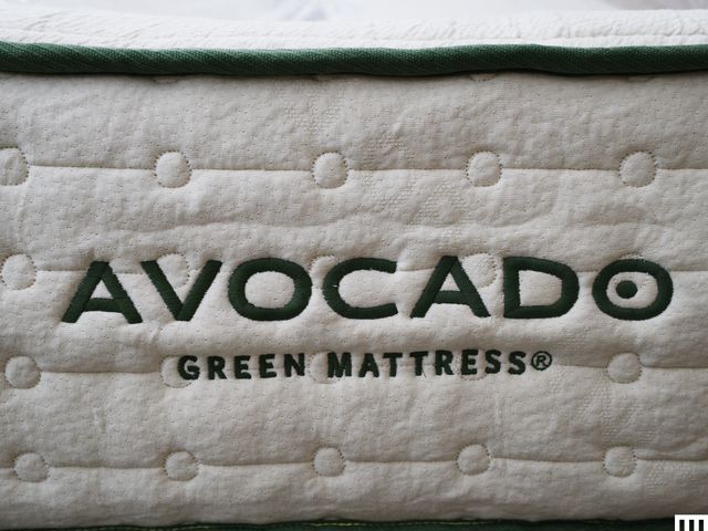 Closeup of an Avocado Green Mattress showing the thick white side with green trim