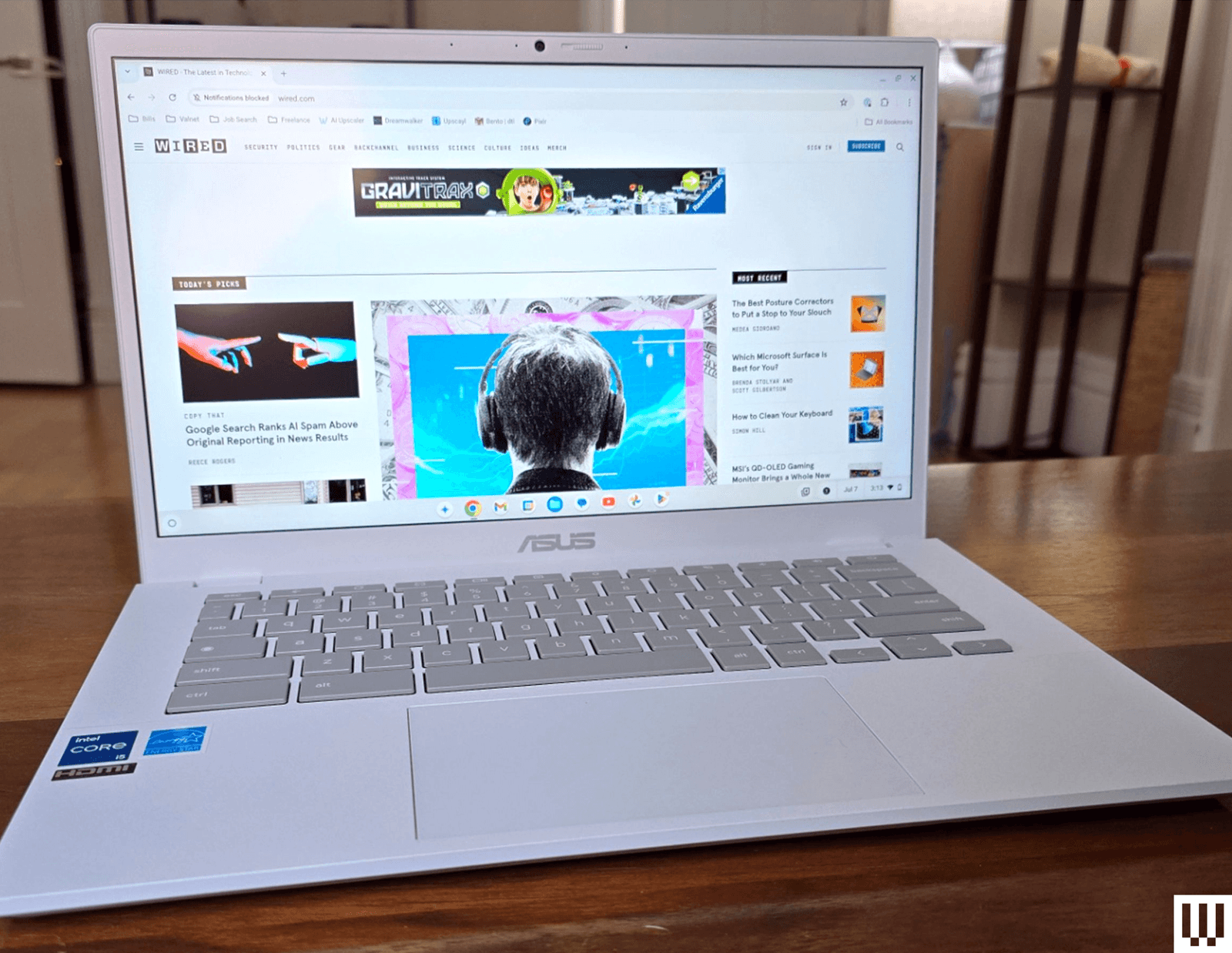 W white laptop fully opened sitting on a wooden desk