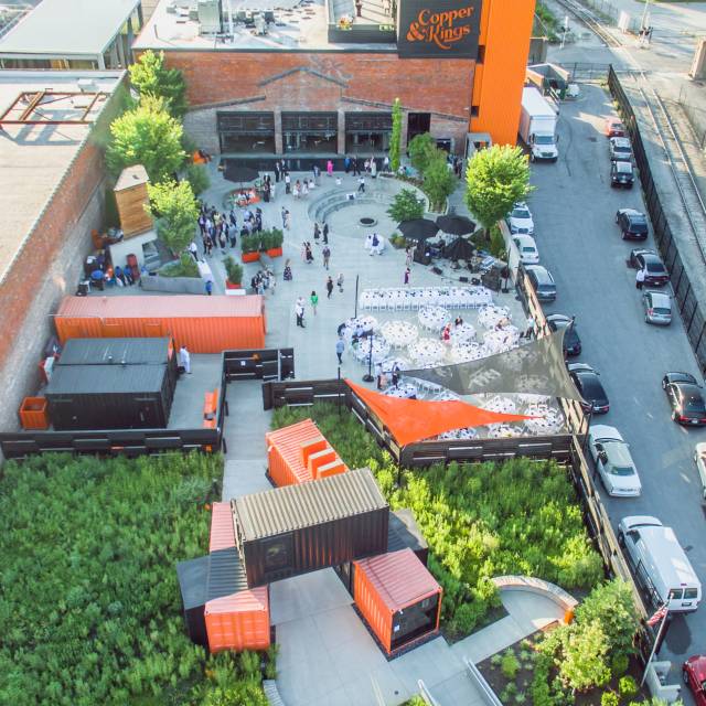 A drone overhead shot of the courtyard at Copper & Kings distillery during the day.