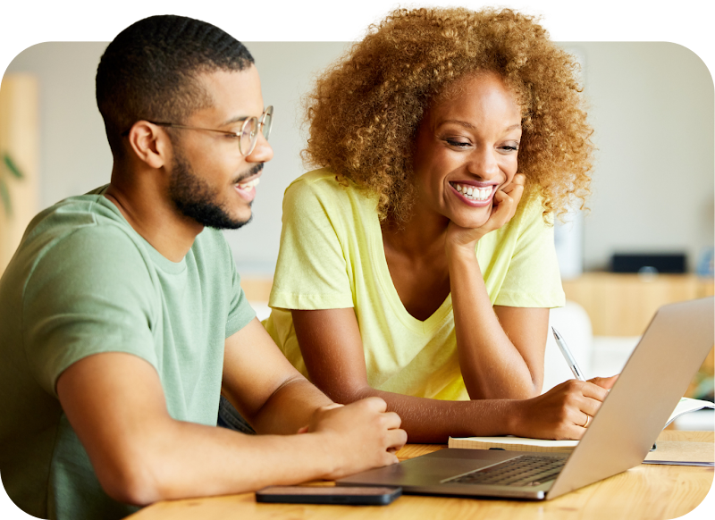 Two people working together, looking at a laptop screen