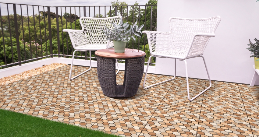 Cozy balcony with hexagonal tile flooring, two white chairs, and a small round table.